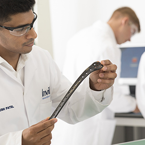 Invibio employee inspecting a trauma plate 