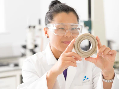 Woman holding a gear for inspection