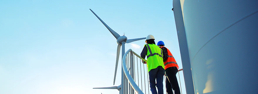 Two male engineers studying a wind turbine