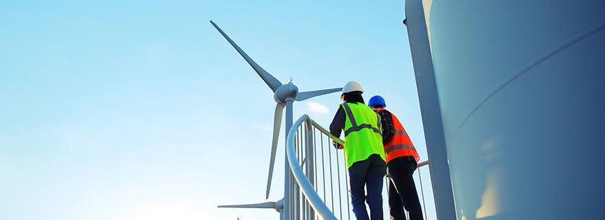 Two male engineers studying a wind turbine 