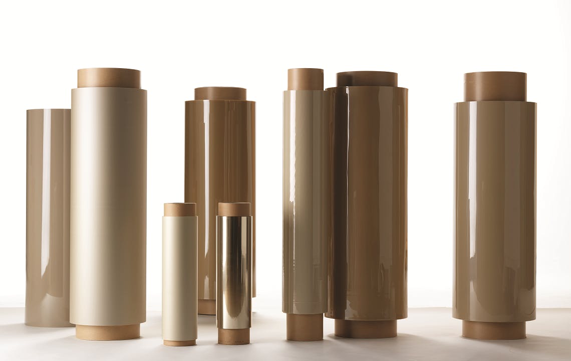 Rolls of APTIV™ PEEK film beside text highlighting APTIV™ PEEK's durability and performance  for aerospace, electronics, and industrial use.